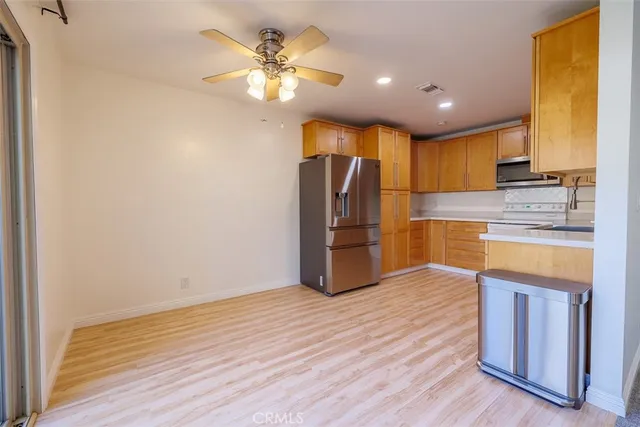 a kitchen with stainless steel appliances granite countertop a refrigerator and a stove top oven