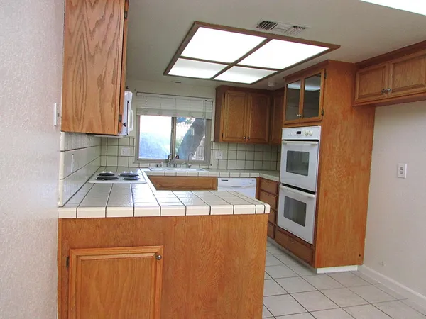 a kitchen with granite countertop a stove sink and cabinets