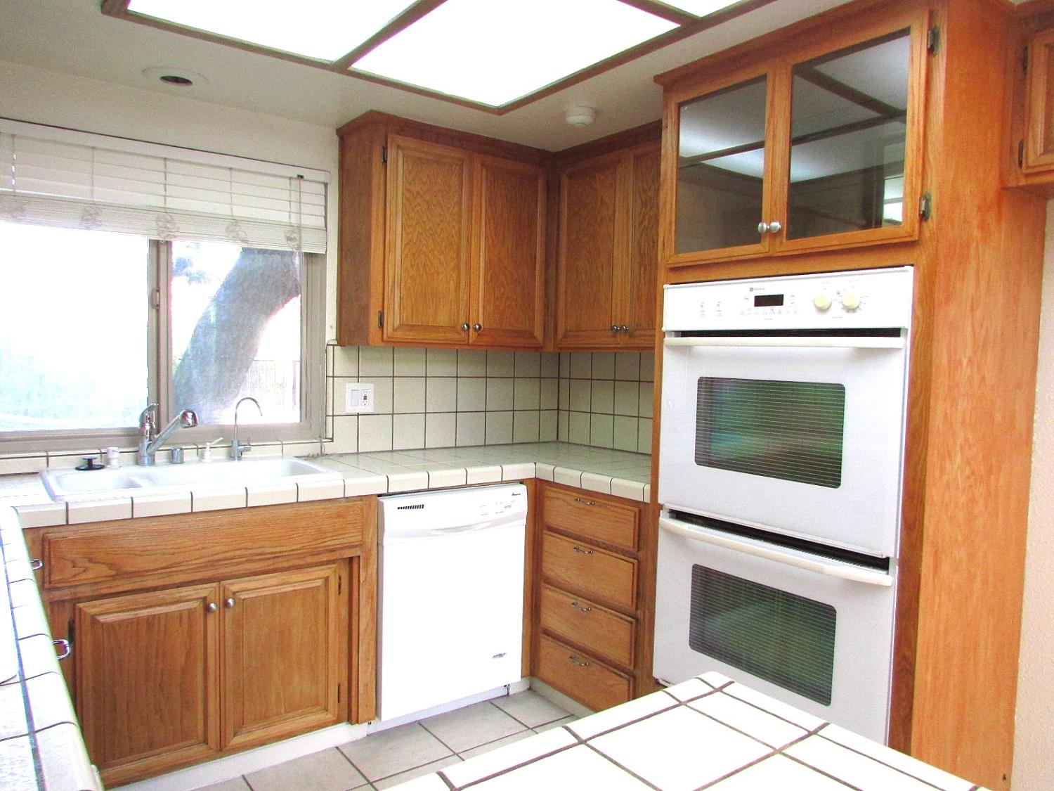 1855 Scenic Drive, Unit F Modesto, CA 95355 - Photo 22 of 52 a kitchen with granite countertop a stove sink and cabinets