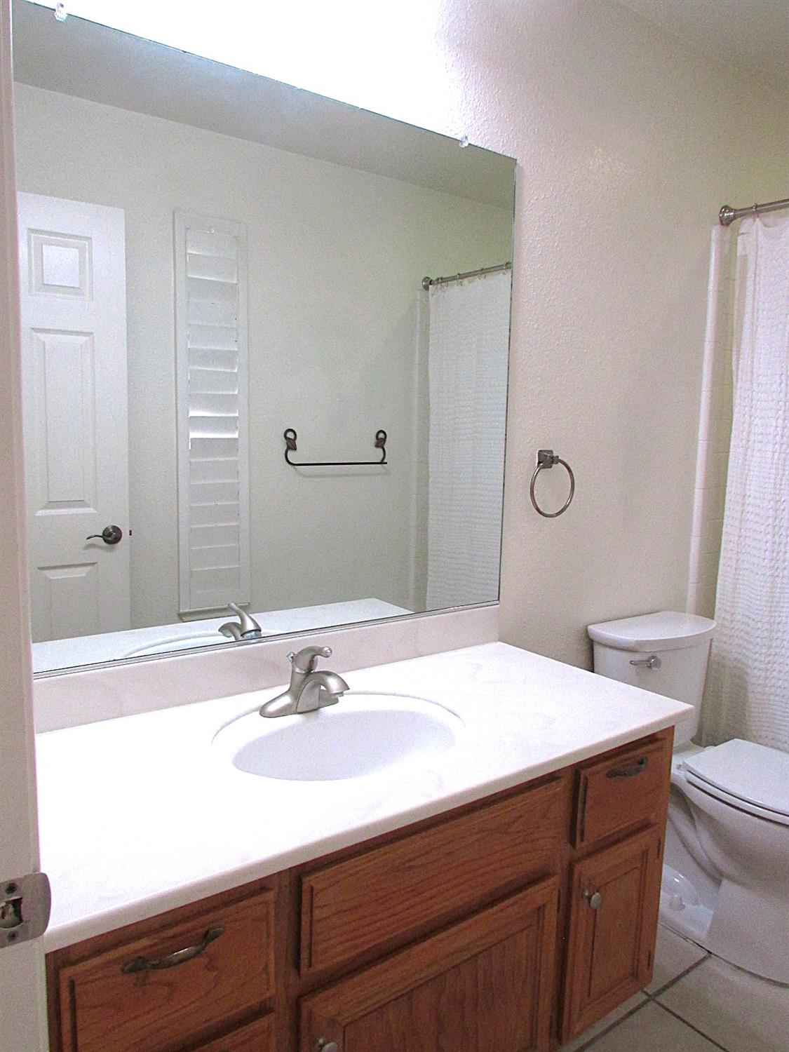 1855 Scenic Drive, Unit F Modesto, CA 95355 - Photo 33 of 52 a bathroom with a sink and a mirror