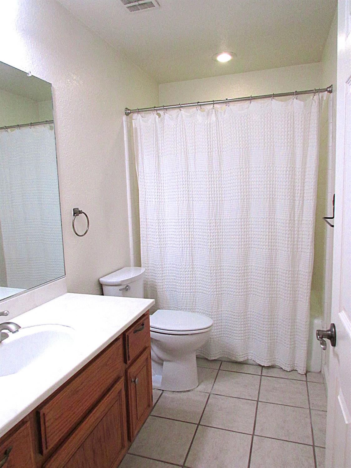 1855 Scenic Drive, Unit F Modesto, CA 95355 - Photo 34 of 52 a bathroom with a sink a toilet and shower