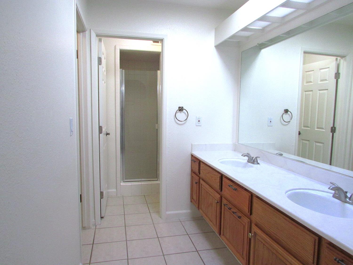 1855 Scenic Drive, Unit F Modesto, CA 95355 - Photo 42 of 52 a spacious bathroom with a double vanity sink a mirror and a