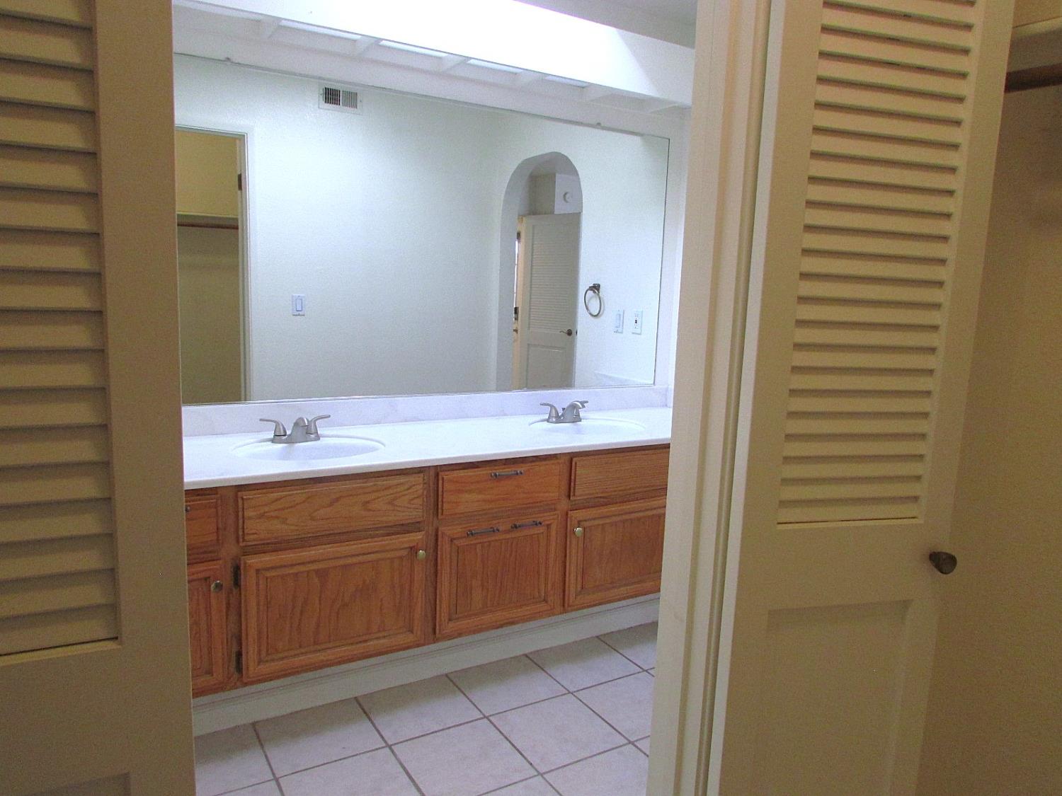 1855 Scenic Drive, Unit F Modesto, CA 95355 - Photo 47 of 52 a spacious bathroom with a double vanity sink and a mirror