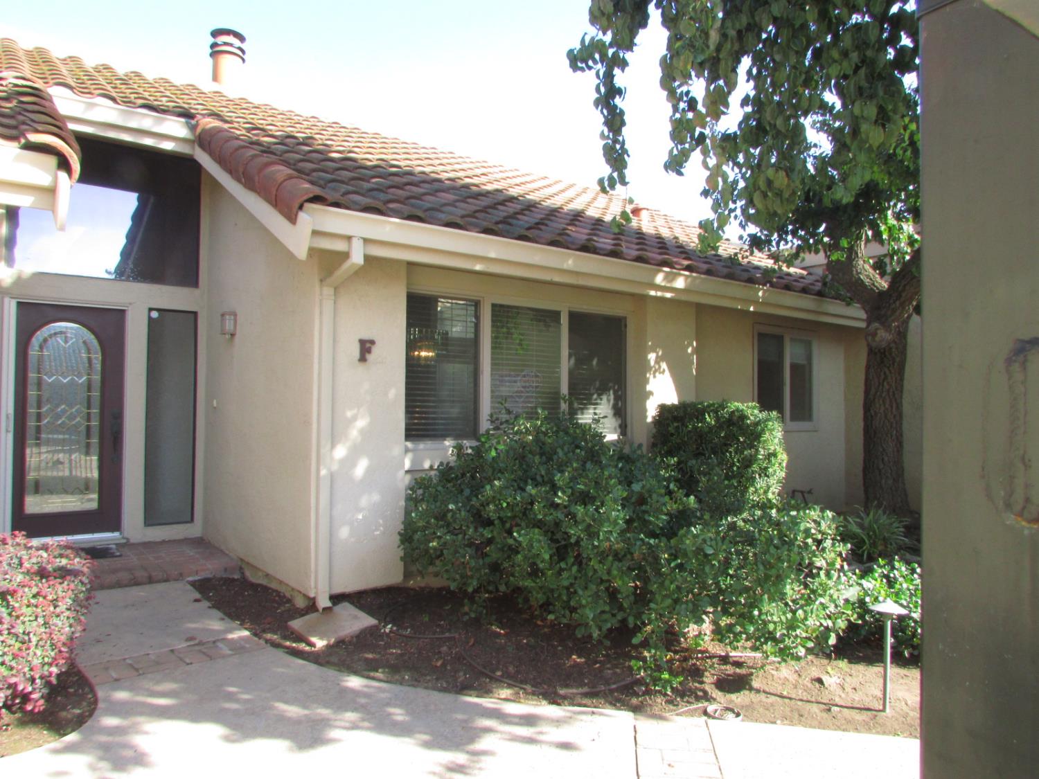 1855 Scenic Drive, Unit F Modesto, CA 95355 - Photo 6 of 52 a view of a brick house with potted plants