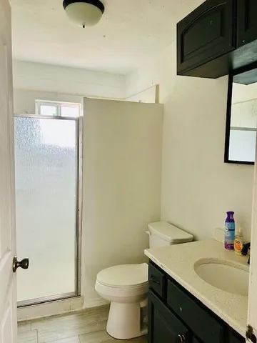 a bathroom with a granite countertop sink toilet and a mirror