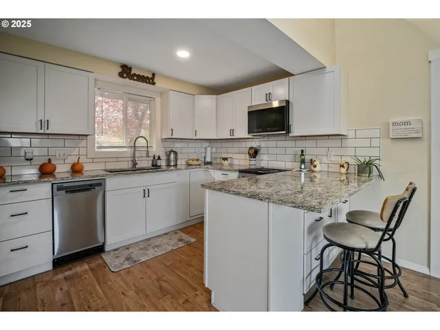 a kitchen with granite countertop a sink stove and cabinets