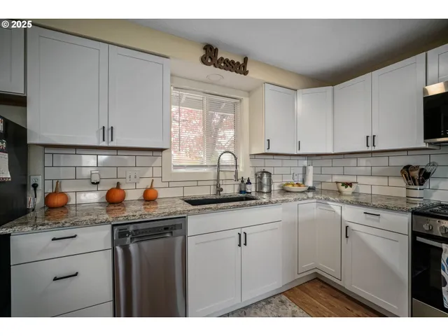 a kitchen with stainless steel appliances granite countertop a sink stove and cabinets