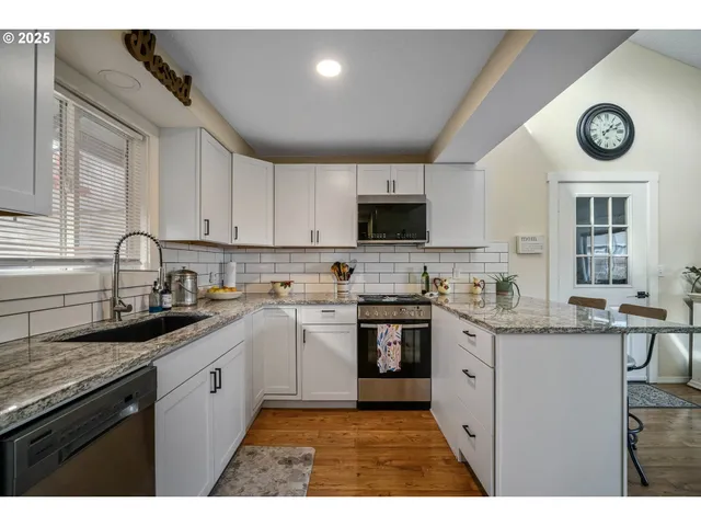 a kitchen with granite countertop a sink stove and cabinets