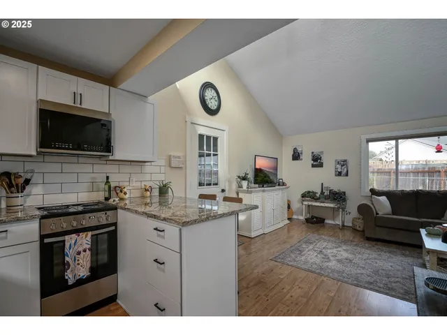 a kitchen with a sink dishwasher stove and white cabinets