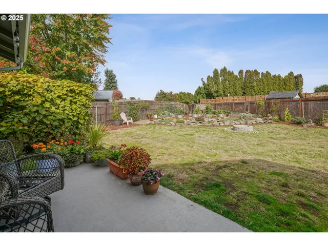 a view of a backyard with plants and lake view