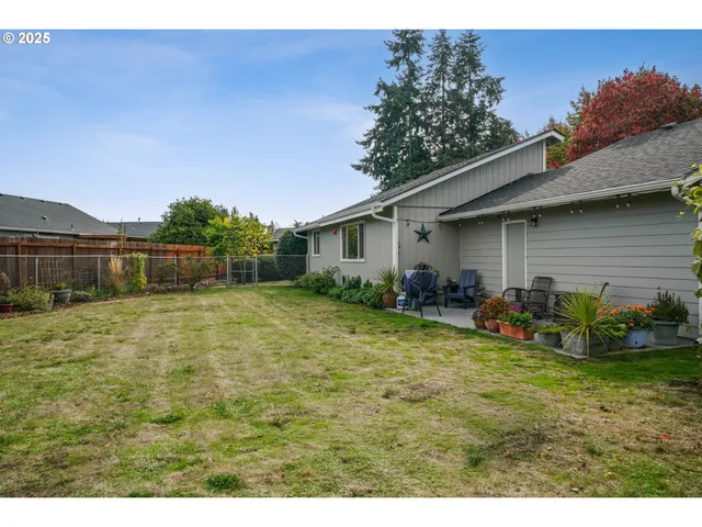 a backyard of a house with table and chairs