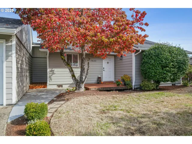 a view of a house with a tree and wooden fence