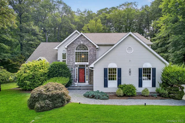 a front view of a house with a garden and plants