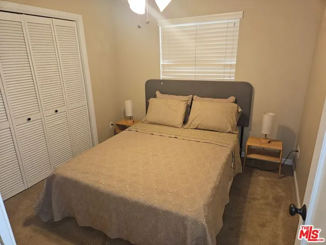 a bed sitting in a bedroom next to a window