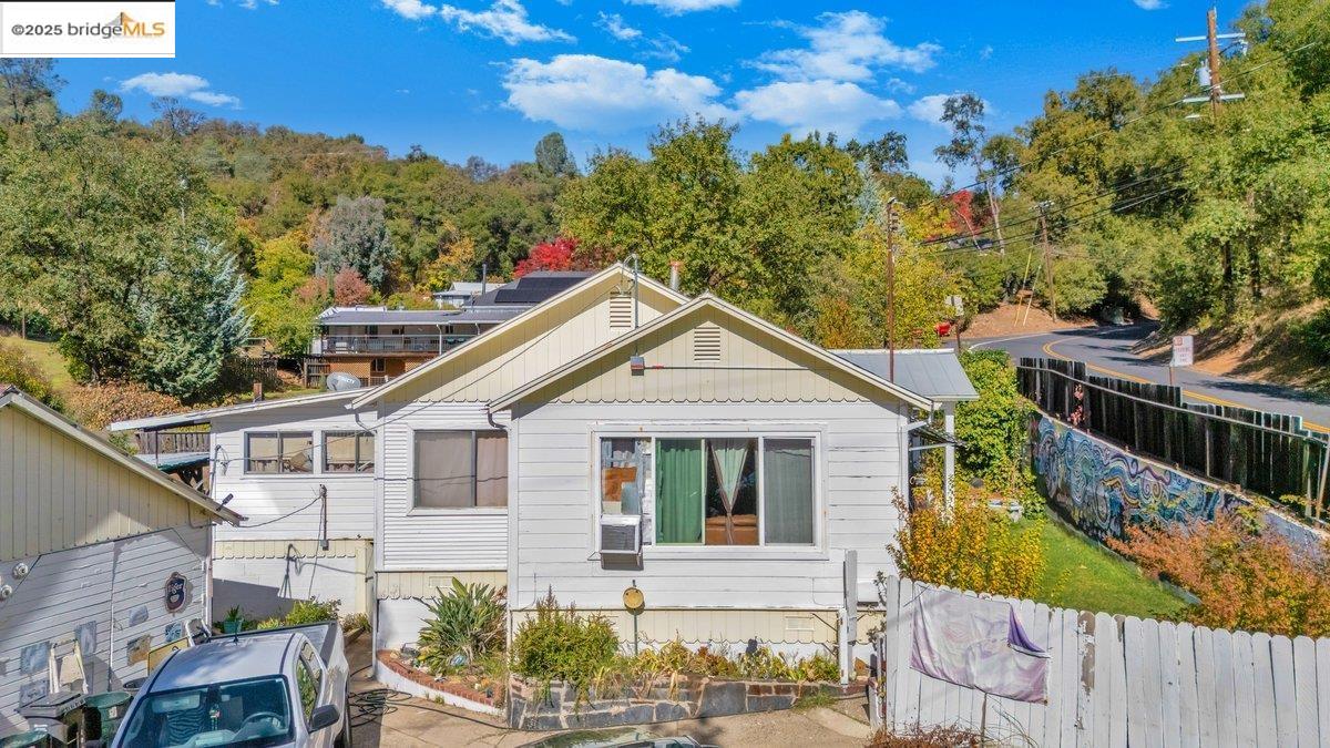 832 Shaws Flat Road Sonora, CA 95370 - Photo 15 of 22 a view of a white house with a small yard and wooden fence