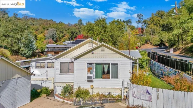a view of a white house with large windows and a small yard