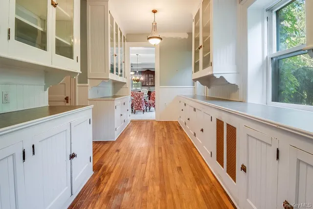 a view of a kitchen with wooden floor and electronic appliances