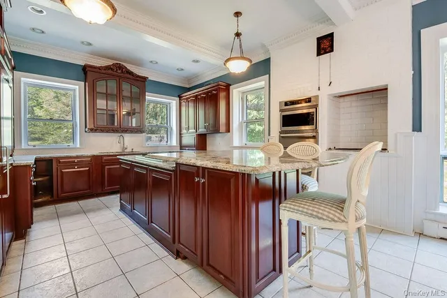 a kitchen with stainless steel appliances granite countertop a stove a sink dishwasher a dining table and chairs with wooden floor