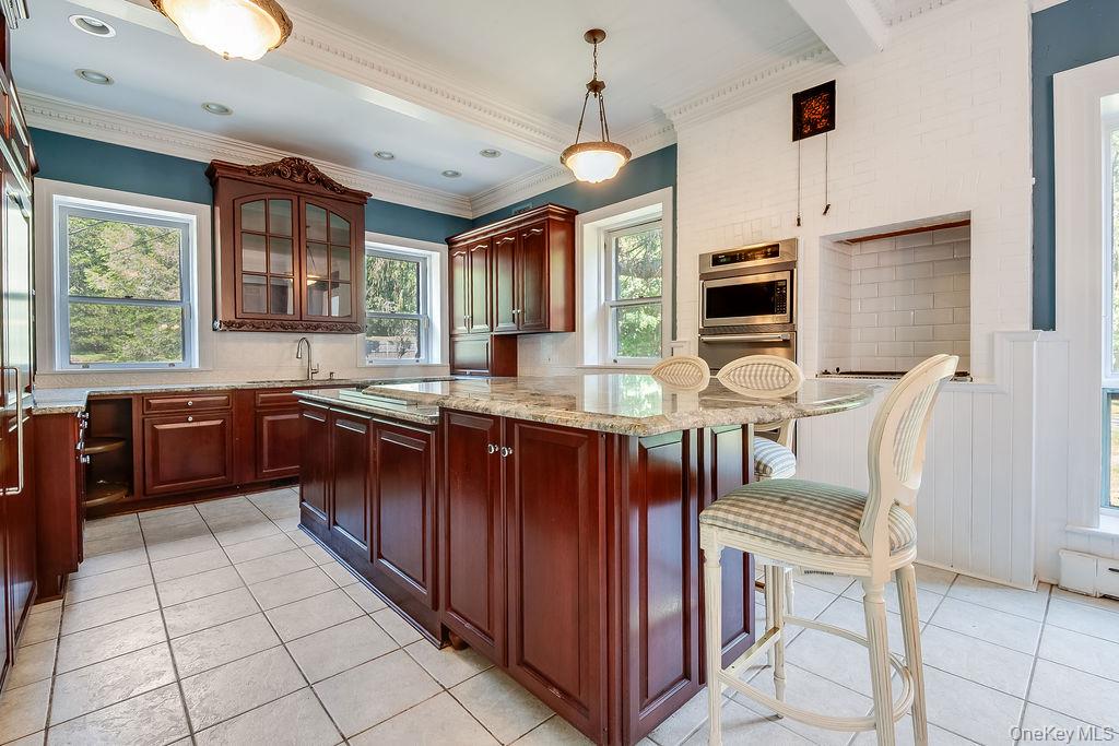24 Jill Road Highland Mills, NY 10930 - Photo 16 of 43 a kitchen with stainless steel appliances granite countertop a stove a sink dishwasher a dining table and chairs with wooden floor