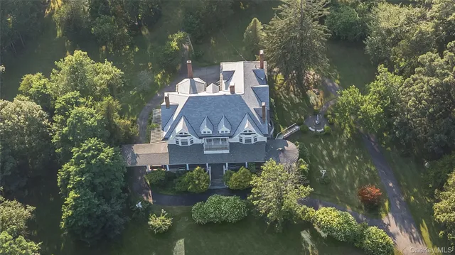 an aerial view of a house with a yard lake and outdoor seating