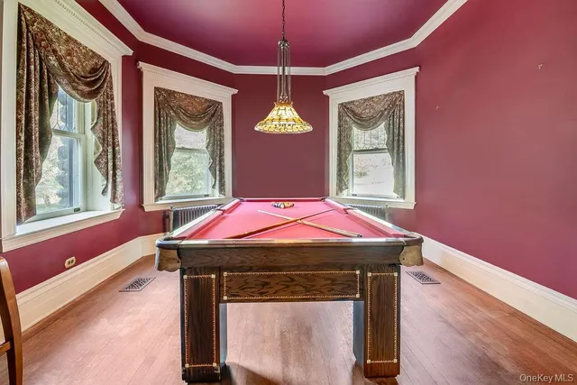 a room with pool table and windows