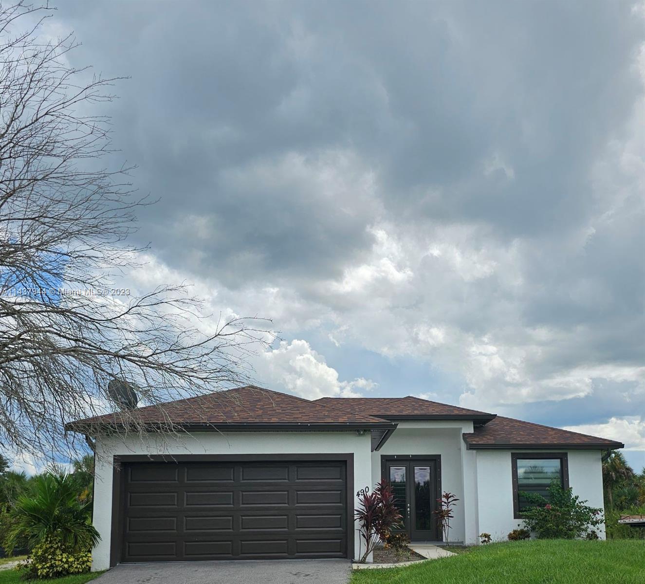 490 37th Avenue Northwest Naples, FL 34120 - Photo 1 of 16 a front view of a house with garden
