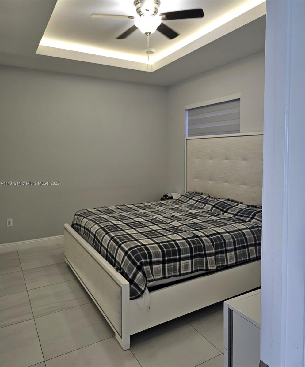 490 37th Avenue Northwest Naples, FL 34120 - Photo 11 of 16 a bedroom with a bed and a chandelier fan