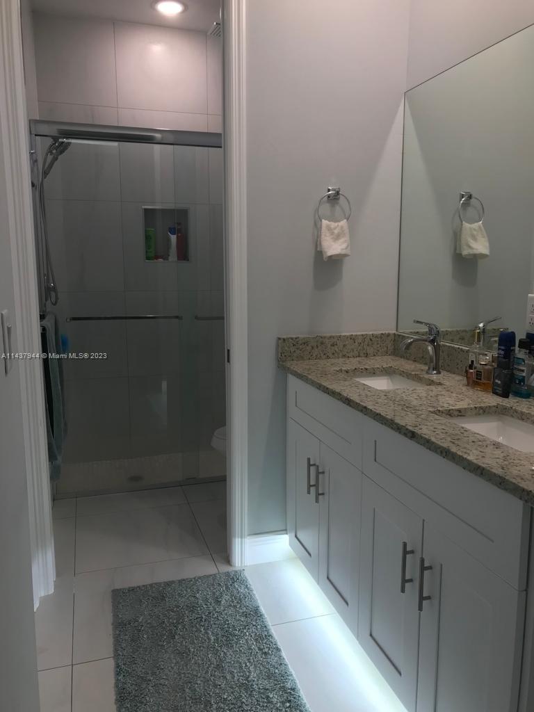 490 37th Avenue Northwest Naples, FL 34120 - Photo 13 of 16 a bathroom with a granite countertop sink a mirror and shower