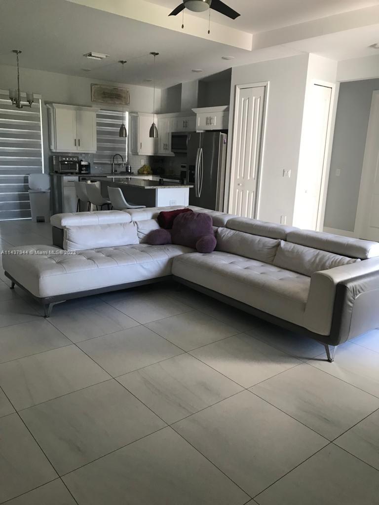 490 37th Avenue Northwest Naples, FL 34120 - Photo 5 of 16 a living room with furniture and a flat screen tv