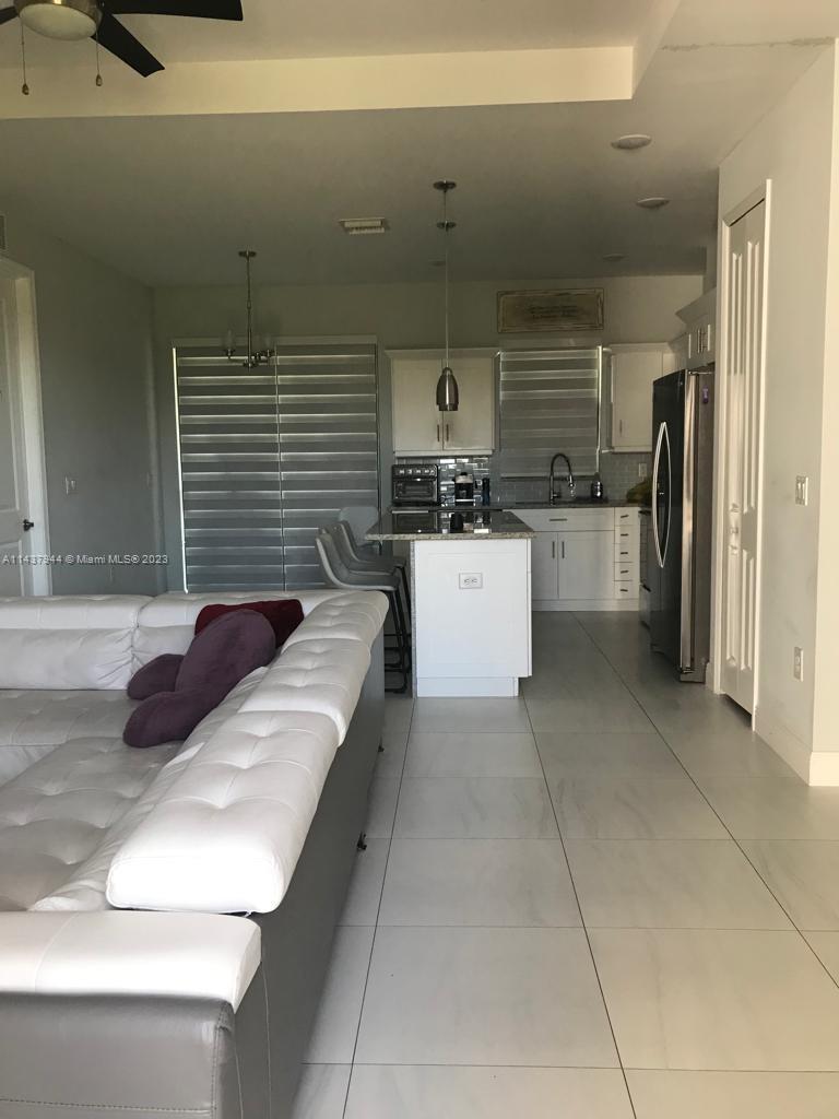 490 37th Avenue Northwest Naples, FL 34120 - Photo 6 of 16 a living room with stainless steel appliances furniture a refrigerator and a kitchen counter tops