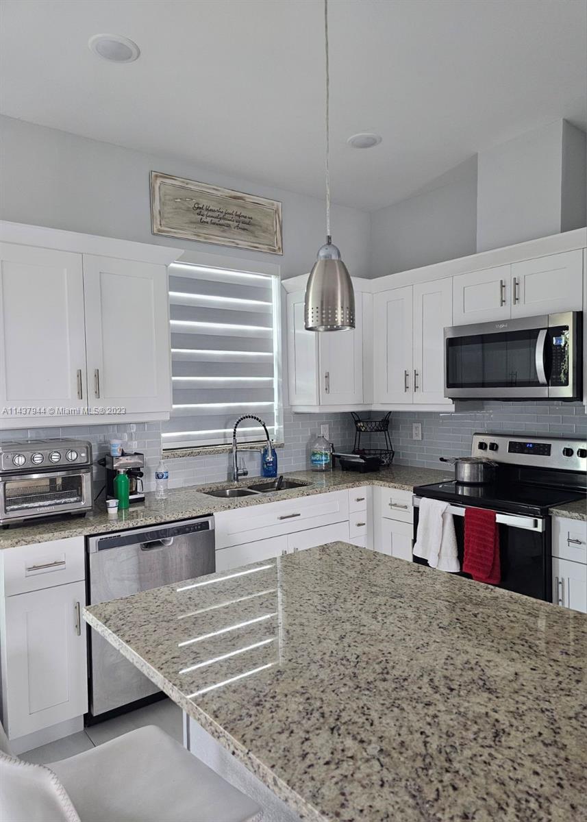 490 37th Avenue Northwest Naples, FL 34120 - Photo 8 of 16 a kitchen with stainless steel appliances granite countertop a stove sink and cabinets