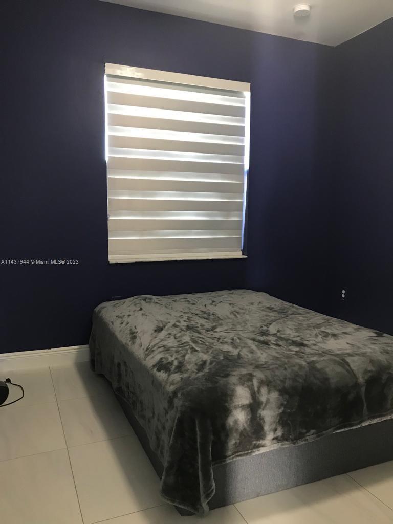 490 37th Avenue Northwest Naples, FL 34120 - Photo 10 of 16 a bed sitting in a bedroom next to a window