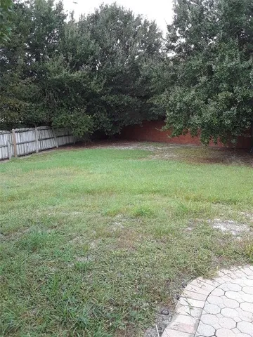 a view of a house with backyard and trees