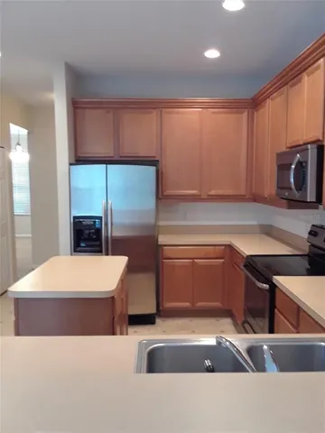 a kitchen with stainless steel appliances wooden cabinets a stove and a sink