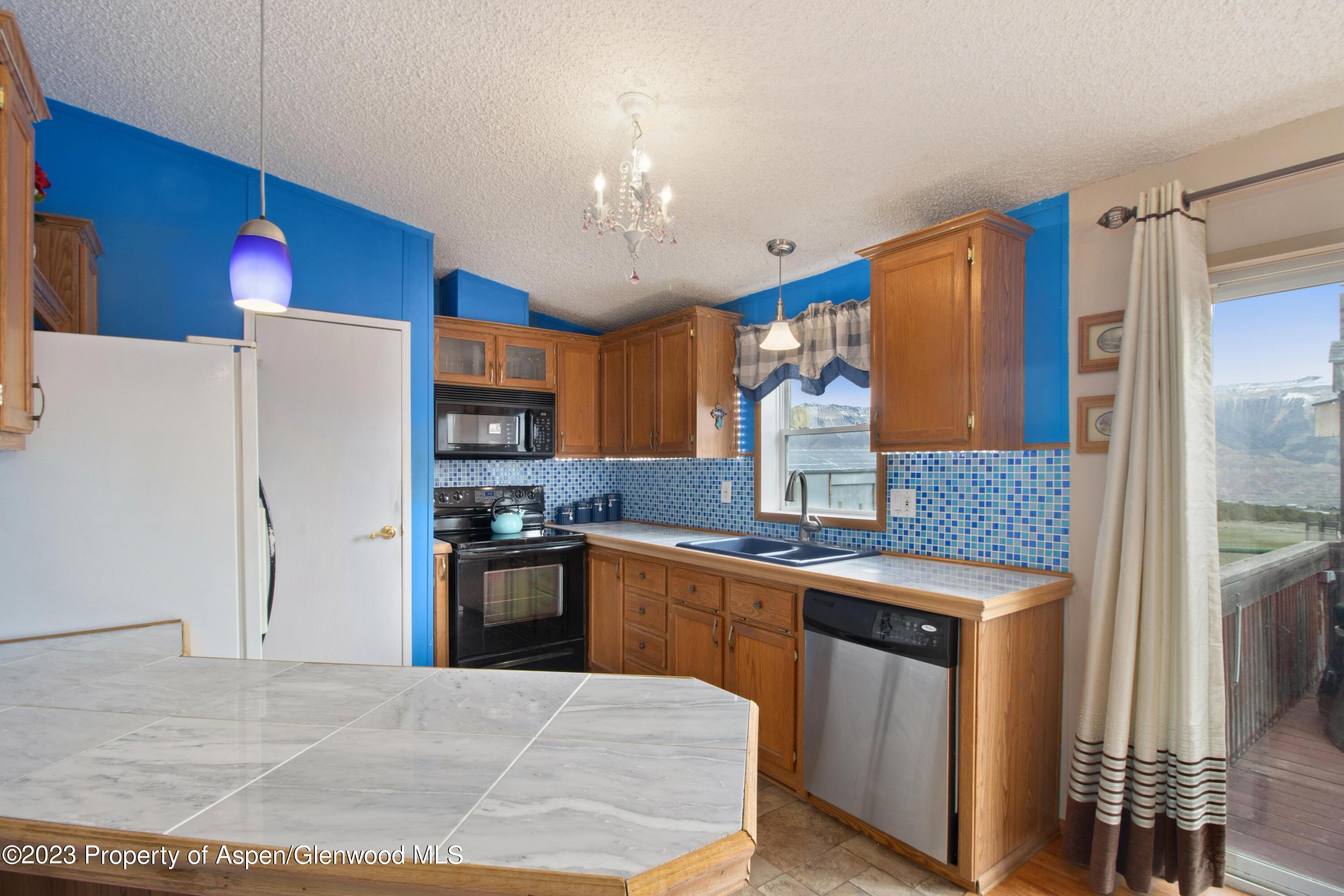 2345 County Road 306 Parachute, CO 81635 - Photo 4 of 29 a kitchen with stainless steel appliances granite countertop a refrigerator a stove and a sink