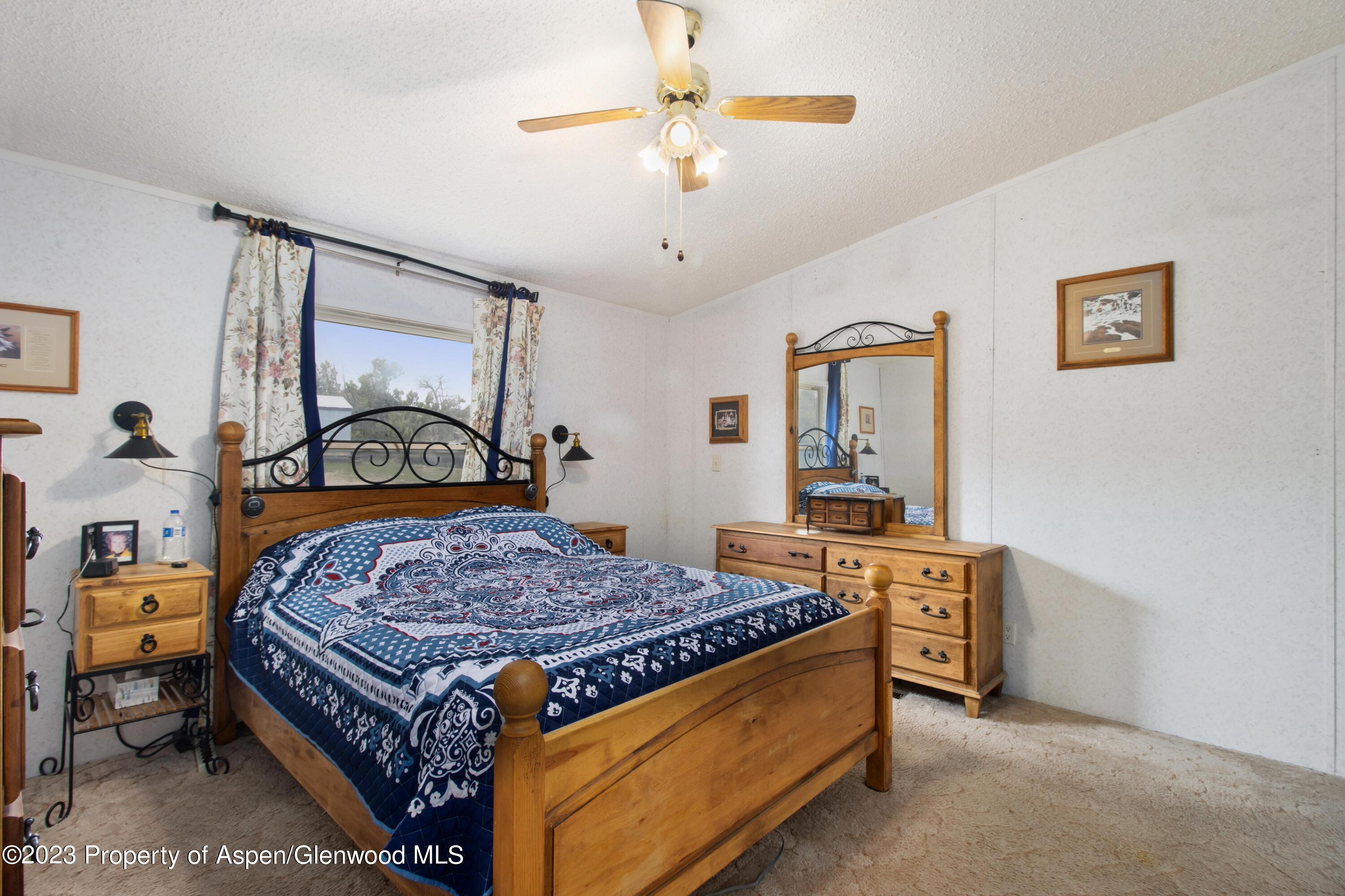 2345 County Road 306 Parachute, CO 81635 - Photo 9 of 29 a bedroom with a bed a chandelier and dresser