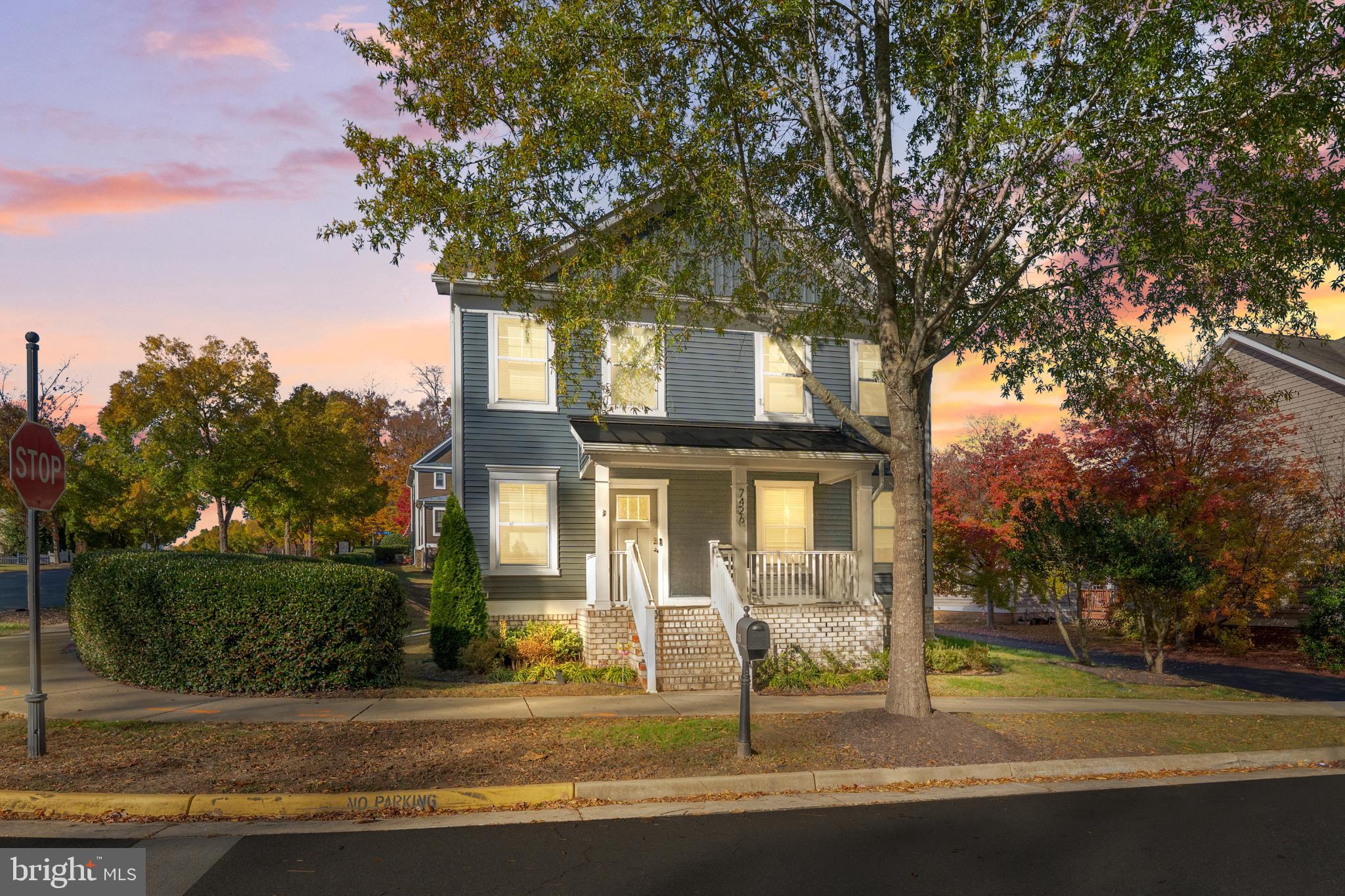 a front view of a house with a tree