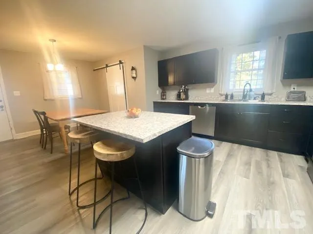 a kitchen with a table chairs sink and cabinets