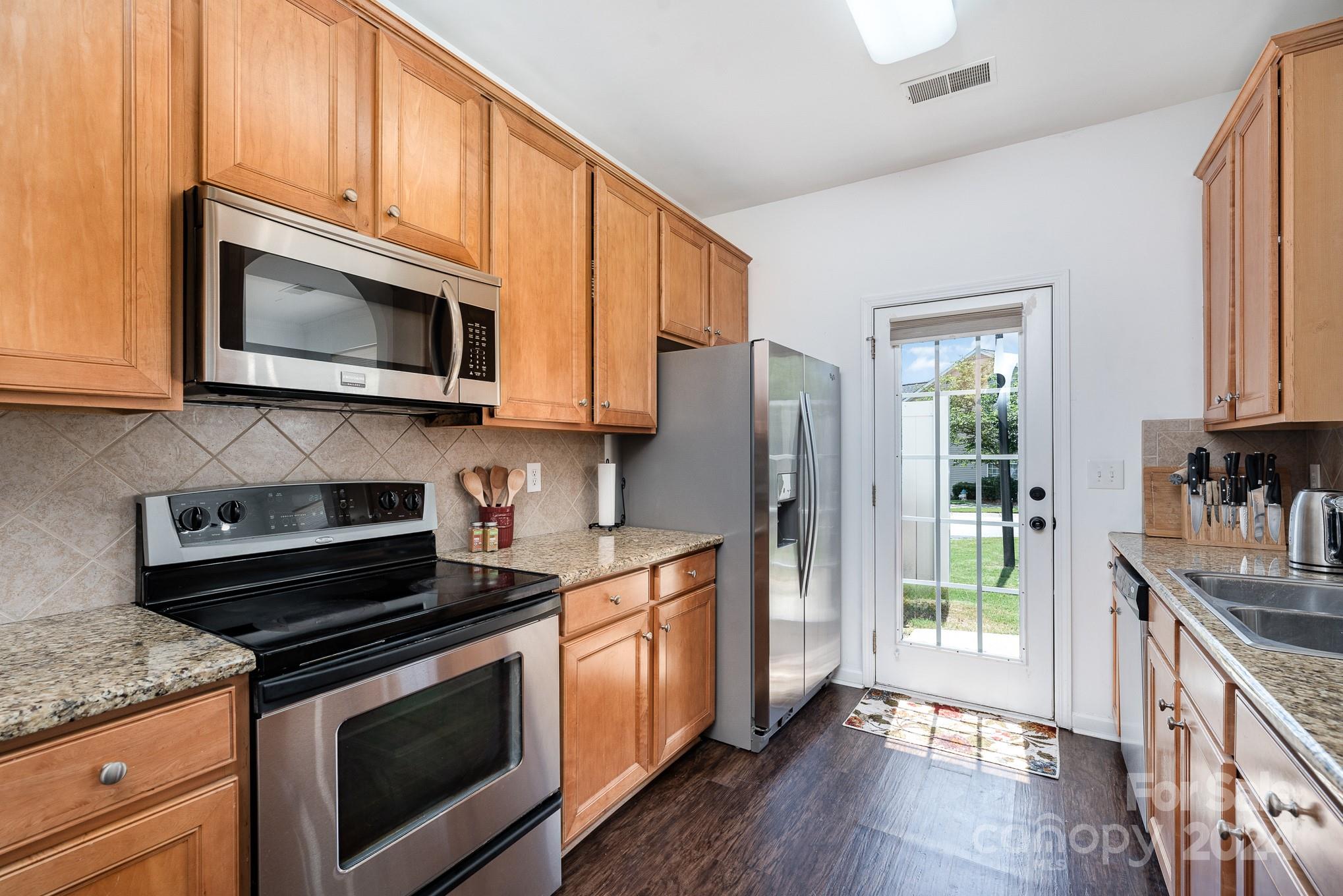 1912 Travertine Lane Fort Mill, SC 29708 - Photo 5 of 25 a kitchen with stainless steel appliances granite countertop a stove microwave and refrigerator