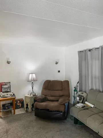 a living room with furniture a lamp and a window