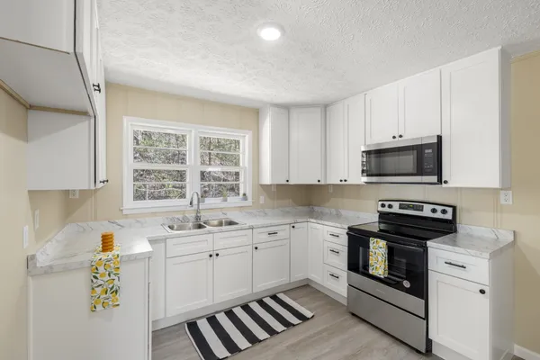 a kitchen with a sink stove and microwave