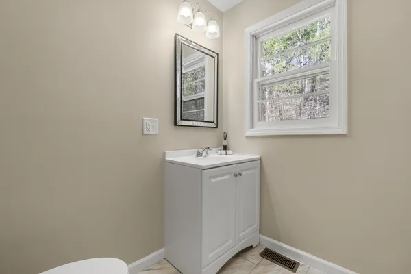 a bathroom with a sink mirror and toilet
