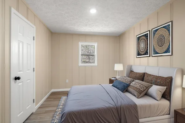 a bedroom with a bed and the painting on the wall