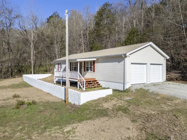 a view of a house with a yard and sitting area