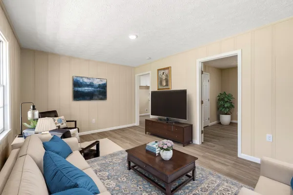 a living room with furniture a rug and a flat screen tv