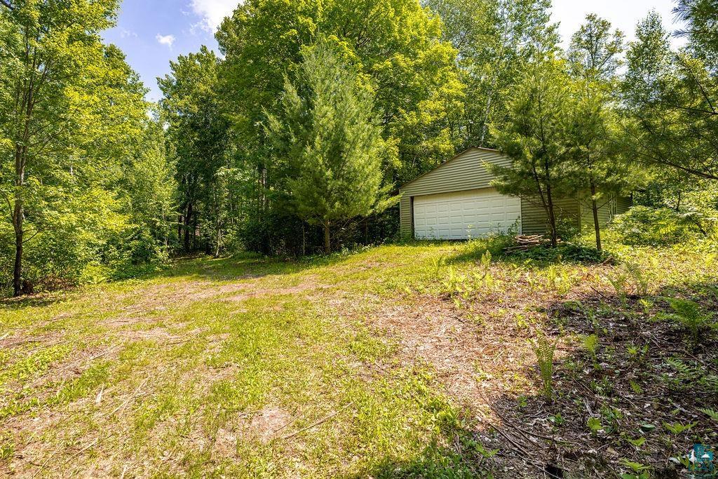 2592 Strandberg Road Barnum, MN 55707 - Photo 30 of 44 Detached two-car garage with horizontal siding, surrounded by mature trees and natural landscaping