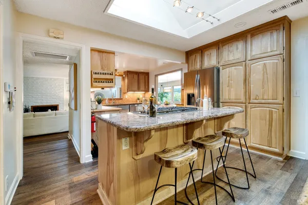 a kitchen with stainless steel appliances granite countertop a stove a sink and a microwave