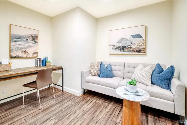 a view of a hallway with wooden floor and furniture