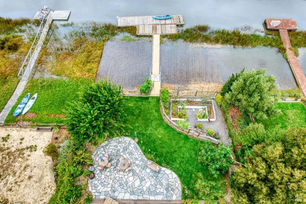 an aerial view of a house with a yard garage and lake view in back