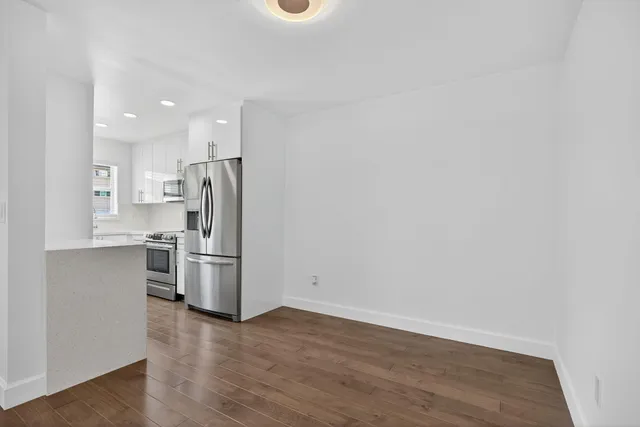 a kitchen with white cabinets and white appliances